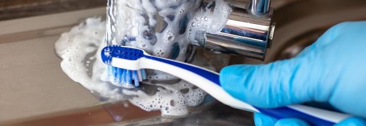 Zahnbürste reinigt den Wasserhahn
